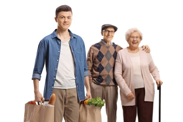 Giovane Uomo Aiutare Una Coppia Anziana Con Sacchetti Alimentari Isolati — Foto Stock