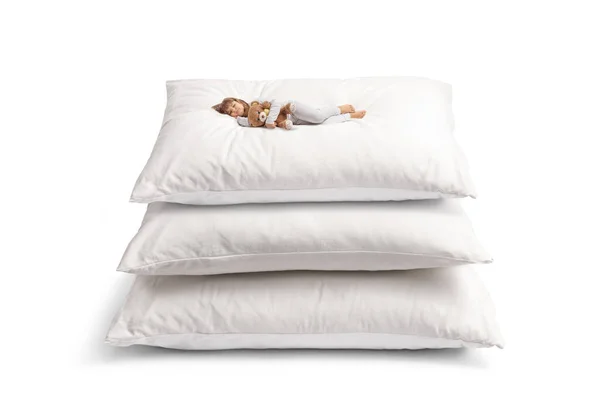 穿着睡衣 头戴玩具熊 睡在一堆白色背景的大软垫枕头上的孩子 — 图库照片