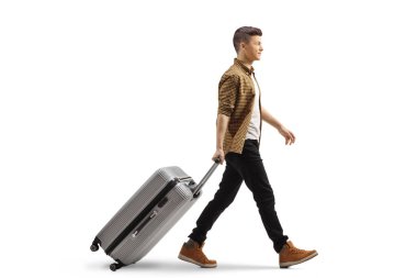Beyaz arka planda yürüyen ve bavulu çeken bir adamın tam boy profil fotoğrafı.