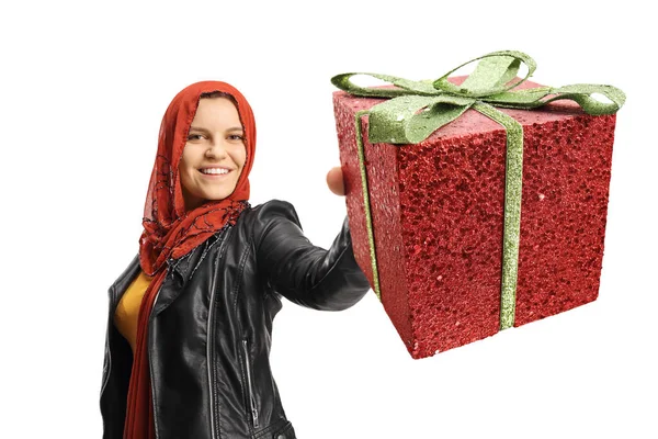 白い背景に孤立した赤いプレゼントを示すヒジャーブを持つ若い女性 — ストック写真