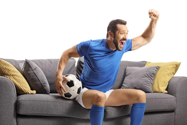 Football Player Sitting Sofa Holding Ball Watching Match Isolated White — Stock Photo, Image