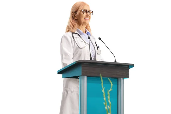 Leende Kvinnlig Läkare Hålla Ett Tal Piedestal Isolerad Vit Bakgrund — Stockfoto