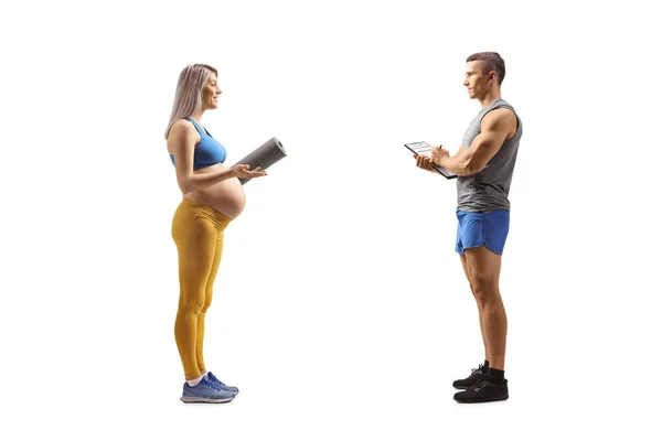 Schwangere Sportbekleidung Gespräch Mit Einem Fitnesstrainer Auf Weißem Hintergrund — Stockfoto