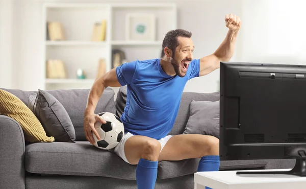 Fußballspieler Sitzt Auf Dem Sofa Und Jubelt Und Schaut Sich — Stockfoto