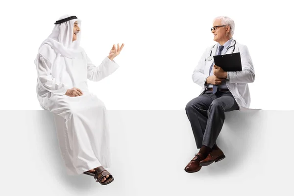 Hombre Árabe Con Bata Étnica Sentado Panel Blanco Hablando Con —  Fotos de Stock