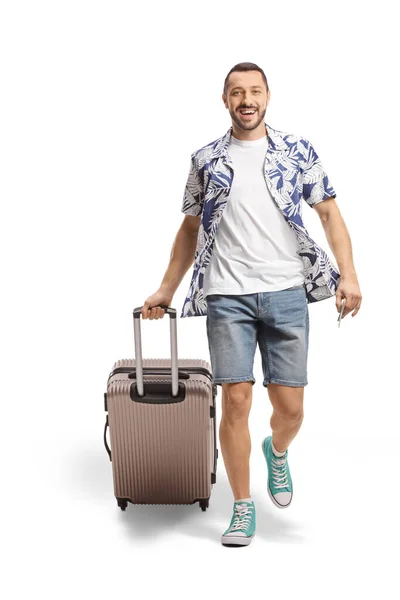 笑顔男歩くと白い背景に隔離されたスーツケースを引っ張っの完全な長さの肖像画 — ストック写真