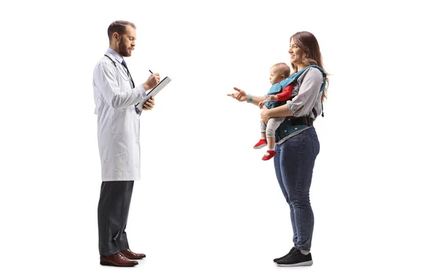 Matka Dzieckiem Rozmawiająca Lekarzem Stojącym Piszącym Dokument Białym Tle — Zdjęcie stockowe