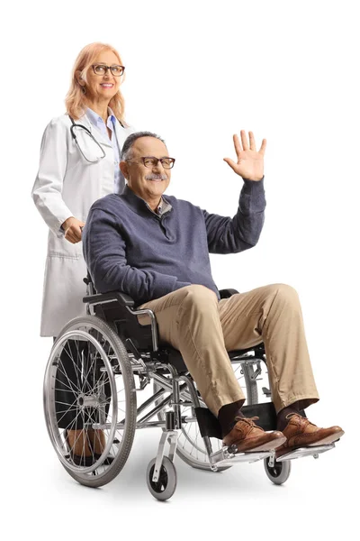 男性患者が車椅子に座り 白い背景に隔離された後ろに立つ女性医師と手を振る — ストック写真