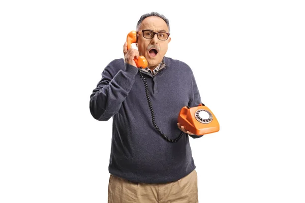 Šokovaný Starší Muž Pomocí Retro Rotační Telefon Při Pohledu Kameru — Stock fotografie