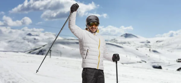 スキーをした男が山の上でスキーポールを持ち上げる — ストック写真