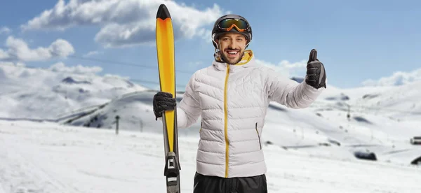 微笑的年轻人 带着滑雪板在山上摆姿势 摆弄着大拇指 — 图库照片