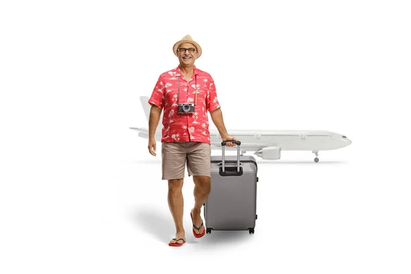 一个成熟的男性游客拖着手提箱从一个白色背景的航班上飞抵的全长肖像 — 图库照片