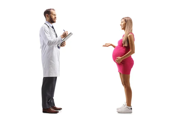 一名孕妇与一位男性妇科医生交谈的全长照片 这名妇科医生被隔离在白人背景下 — 图库照片
