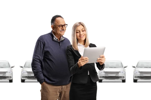 一位女商人用白色背景的数码平板电脑向一位成熟的顾客展示汽车 — 图库照片