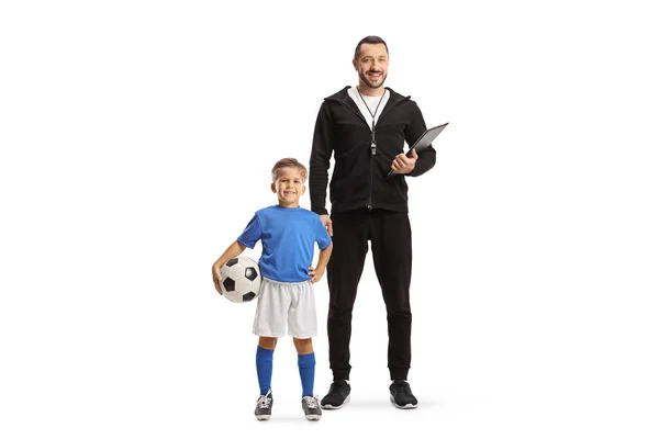 足球教练拿着口哨 手里拿着记事板 旁边站着一个站在白背脊上的男孩 — 图库照片
