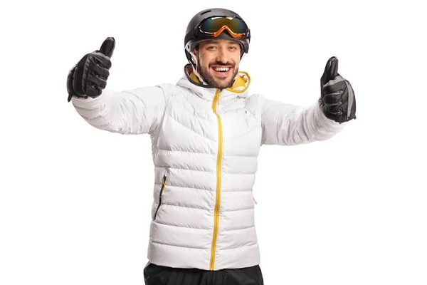 快乐的男子滑雪者在被白色背衬隔开的相机前把两只大拇指举起来 — 图库照片