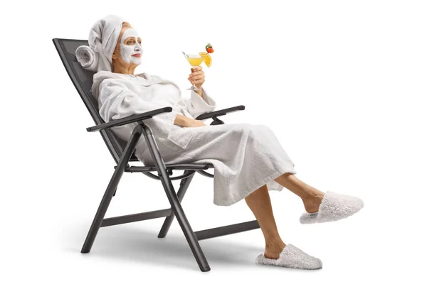 Žena Županu Obličejovou Maskou Sedí Židli Relaxuje Koktejlem Izolované Bílém — Stock fotografie