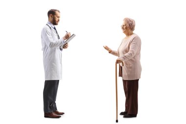 Beyaz arka planda izole edilmiş bir belge yazan yaşlı bir kadın doktorla konuşuyor.