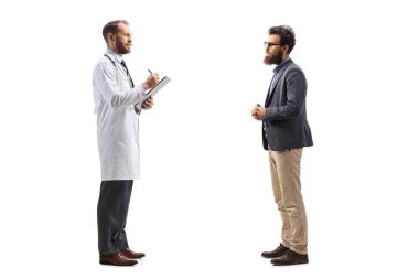 Bir doktorun belge yazarken ve beyaz arka planda izole edilmiş bir erkek hastayla yan yana dururken tam boy profil çekimi.
