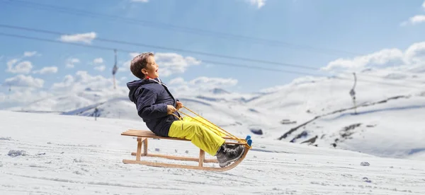 Kayak Merkezinde Tahta Bir Kızakta Kayan Çocuk — Stok fotoğraf