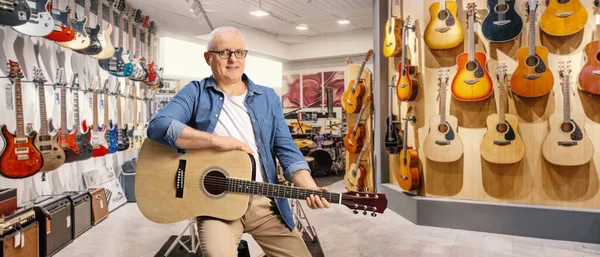 Müzik Dükkanında Akustik Gitarlı Bir Sandalyede Oturan Olgun Bir Adam — Stok fotoğraf