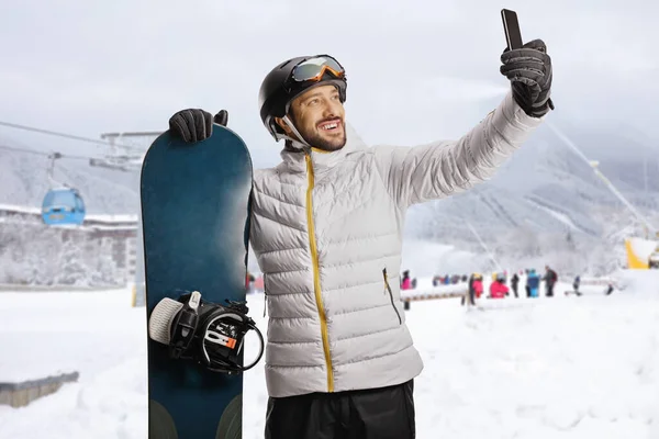 Tipo Com Snowboard Tirar Uma Selfie Com Smartphone Numa Estância — Fotografia de Stock
