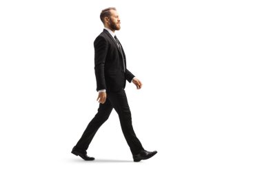 Siyah takım elbiseli profesyonel bir adam beyaz arka planda tek başına yürüyor.