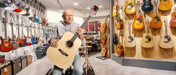 Guitarist Sitting Music Store Holding Acoustic Guitar —  Fotos de Stock