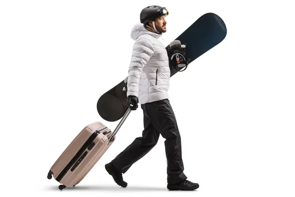 Full Length Profile Shot Young Man Holding Snowboard Pulling Suitcase — Stock fotografie