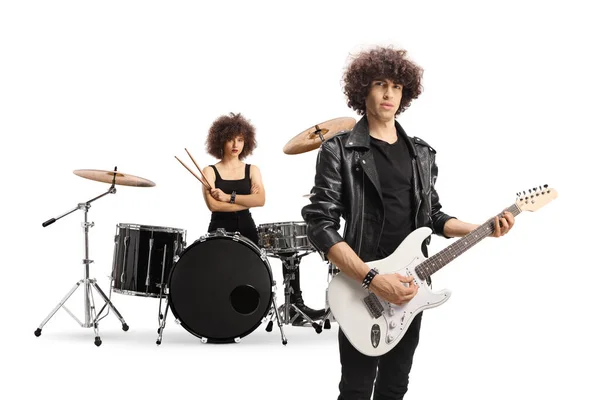 Male musician with an electric guitar and a female drummer in the back isolated on white background