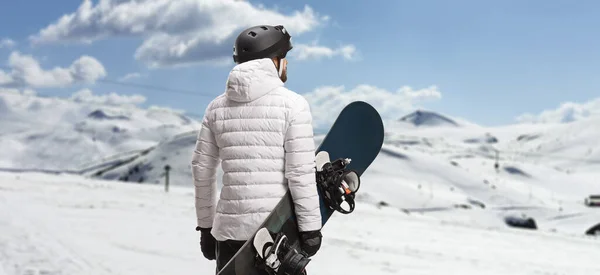 Снимок Сзади Человека Держащего Сноуборд Смотрящего Гору — стоковое фото