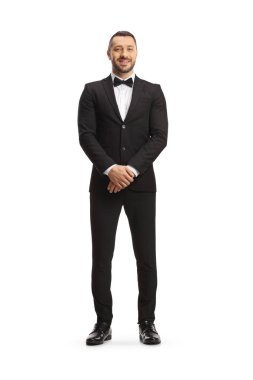 Full length portrait of a handsome man in a black suit with bow tie posing isolated on a white background