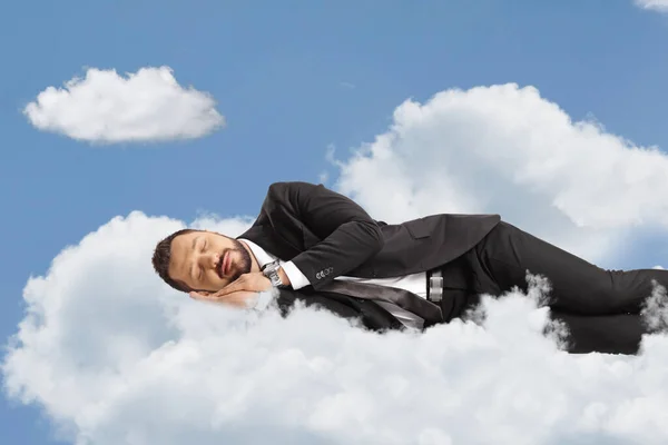 Businessman sleeping over clouds up in the sky
