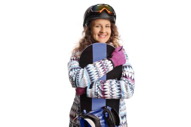 Gözlüklü ve kasklı mutlu genç bir kadın beyaz arka planda izole edilmiş bir snowboard 'a sarılıyor.