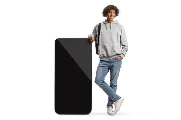 Young African American Male Student Leaning Big Mobile Phone Isolated — Stock fotografie