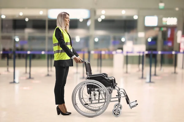 Female Assitance Worker Airport Standing Empty Wheelchair — Stock fotografie