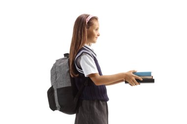 Profile shot of a schoolgirl giving books and smiling isolated on white background