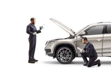 Mechanics checking a suv and cleaning a dipstick for oil check isolated on white background