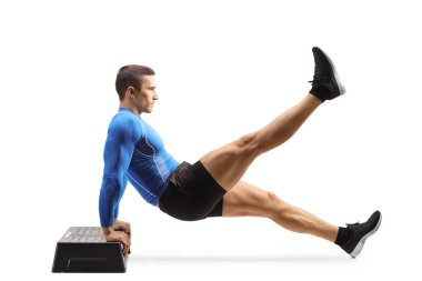 Full length profile shot of a muscular man exercising planks with a stepper isolated on white background
