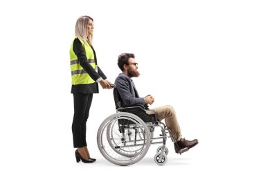 Female special assitance worker standing behind a man in a wheelchair isolated on white background