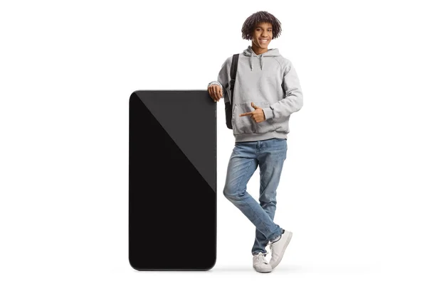 Young African American Male Student Pointing Big Mobile Phone Isolated — Stockfoto