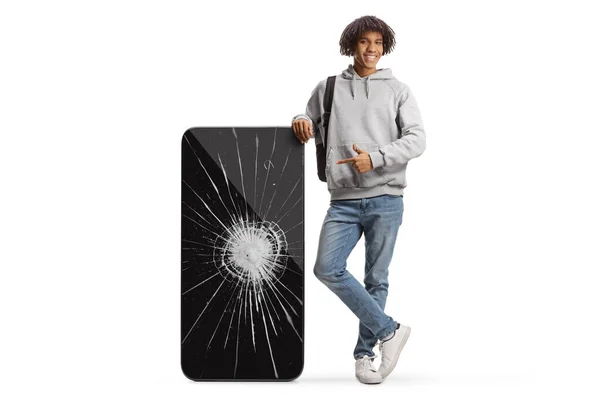 Young African American Male Student Pointing Big Mobile Phone Cracked — Stock fotografie