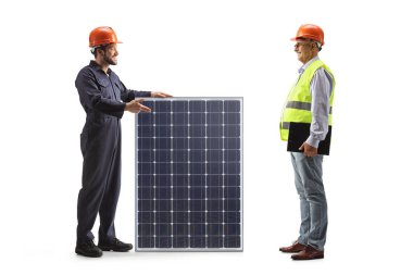 Worker in a uniform and helmet presenting a solar panel to a mature engineer isolated on white background