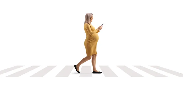 妊娠中の女性は横断歩道を歩いて白い背景に隔離されたスマートフォンを使って — ストック写真