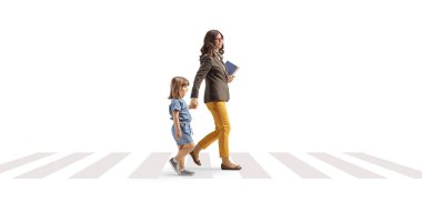 Full length profile shot of a woman carrying books and holding hands with a little girl on a pedestrian crossing isolated on white background