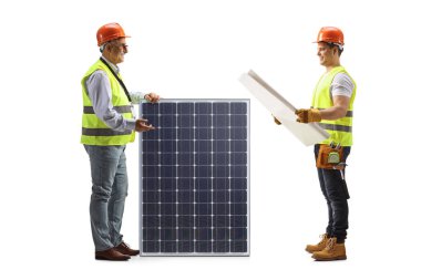 Engineers looking at a blueprint and standing next to a solar panel isolated on white background