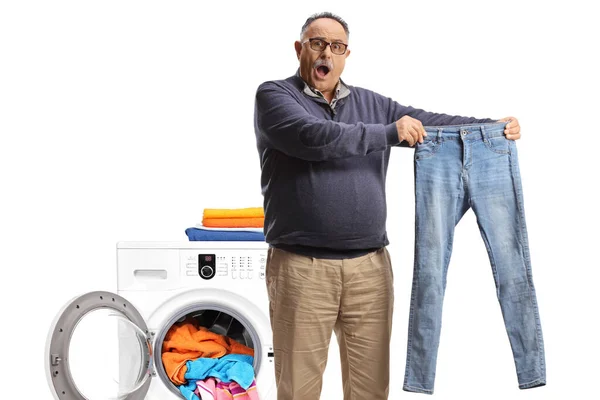 Shocked Mature Man Taking Out Pair Jeans Washing Machine Isolated — Stock fotografie