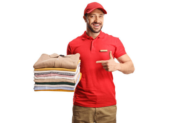 Laundry worker holding a pile of folded clothes and pointing isolated on a white backgroun