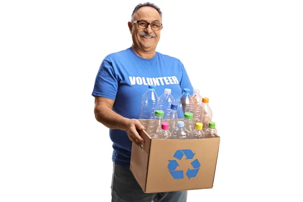 白い背景に隔離されたリサイクルのためのプラスチックボトル付きの箱を保持している陽気な成熟した男性ボランティア — ストック写真