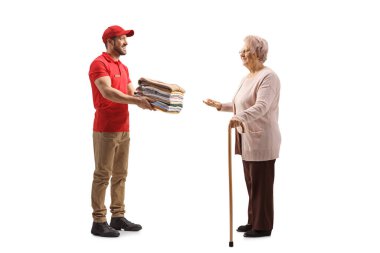 Çamaşır işçisi, beyaz bir banliyöde izole edilmiş yaşlı bir kadına katlanmış giysiler getiriyor.